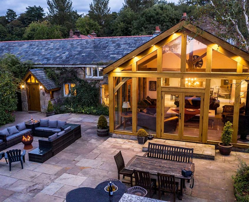 Oakhouse with private patio and fire-pit, lit up at dusk